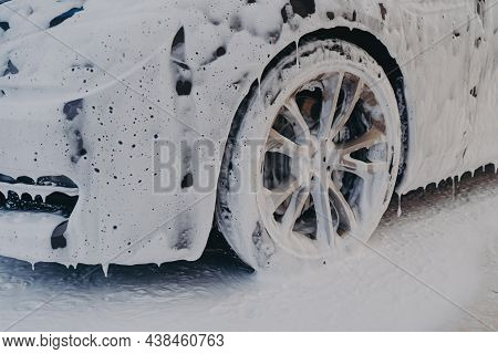 Exterior Car Detailing. Close Up Of Car Wheel In White Soap Foam At Carwashing Service Station, Prof