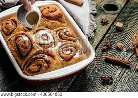 Freshly Baked Sweet Cinnamon Buns Rolls With Vanilla Cream. Food Recipe Background. Close Up,