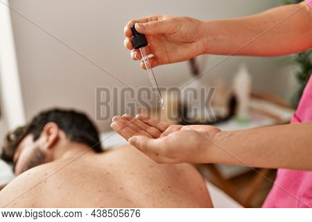 Man reciving back massage with oil at beauty center.