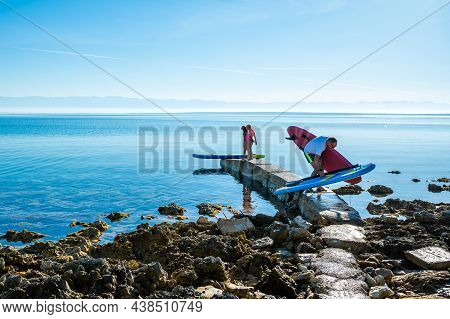Father And Daughter Preparing Sup Stand Up Paddle On Vacation.