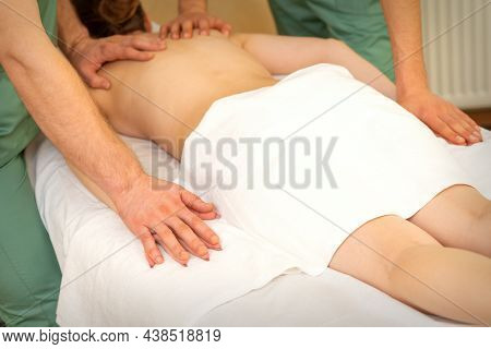 Back And Hands Double Massage With Four Hands Of Two Professional Massagers For A Young Caucasian Wo
