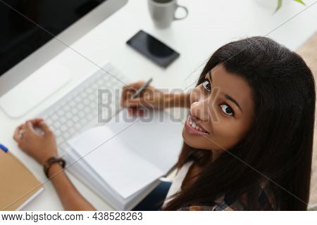 Top View Of Smiling Latin Woman On Workplace, Open Empty Journal, Modern Luxury Devices On Desk. Fir
