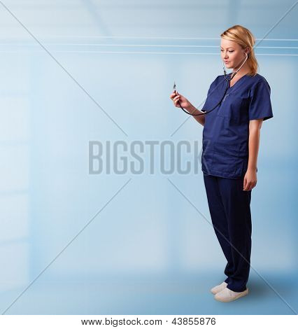 Hübsche junge Krankenschwester im Krankenhaus leer textfreiraum mit Sthetoscope anhören