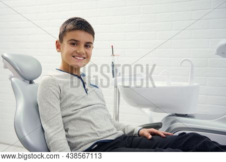 Adorable Child Preadolescent Boy Sitting In Dentist\'s Chair During Dental Appointment For Regular M