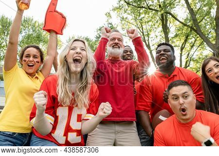 Football fans celebrating the win of their team at a tailgate party
