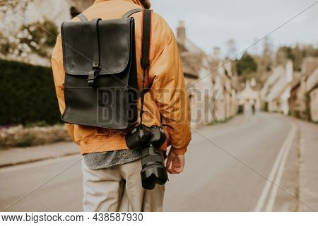 Tourist walking into the village for  rearview