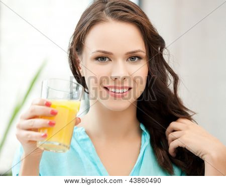 jeune femme tenant le verre de jus d'orange