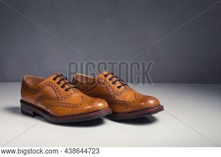 Closeup Of Pair Of Male Full Brogued Tan Oxford Shoes. Horizontal Image