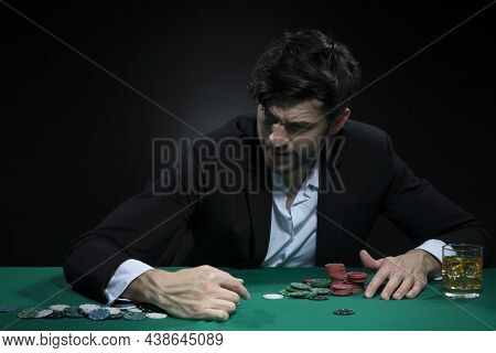 Nervous And Concentrated Handsome Caucasian Brunet Young Pocker Player At Pocker Table With Chips Wh