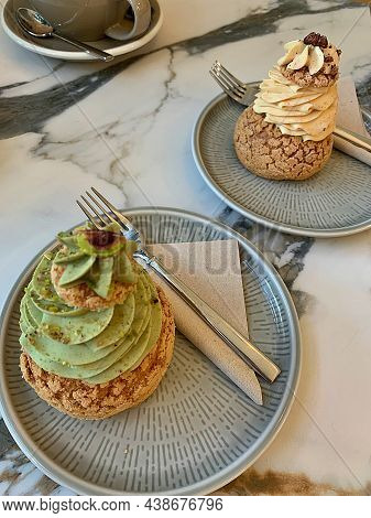 Sugar Puffs On A Plate, Puffs Filled With Creams, Pistachio Cream And Cinnamon Cream, Two Cookies On