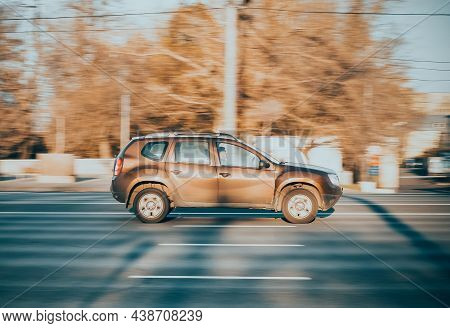 Fast Moving Renault Duster Suv Rides On A Wet City Road. Brown Dacia Duster Car On Autumnal Road In 