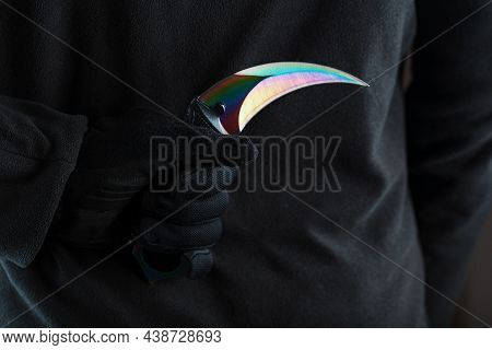 A Criminal With A Sharp Knife Hidden Behind His Back.