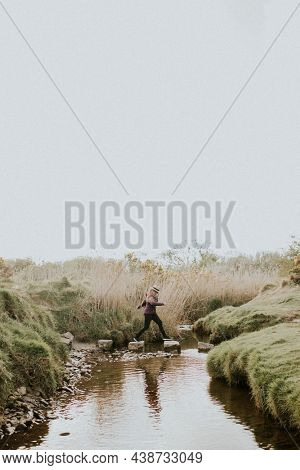 Senior woman hopping through the stepping stones