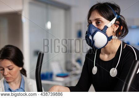 Athlete Woman With Mask Running On Fitness Bycle Trainning Body Endurance While Specialist Doctor Me