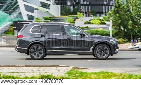 Side View Of Black Bmw X7 Car Riding On The Street On High Speed. Shiny Gray Suv Car In Motion. Urba