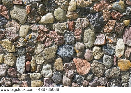 Close Up Of Mixed Pebbles Texture. Pebble Stones Stacked Into A Wall On A Sunny Day