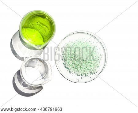Ferrous Sulfate In Chemical Watch Glass Place Next To Iron (ii) Sulfate Liquid In Beaker. Close Up C