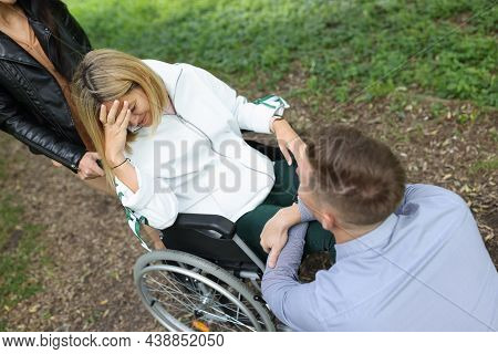 Young Disabled Woman In Wheelchair Crying Near Man Sitting In Front Of Her In Park. Relationship Dif