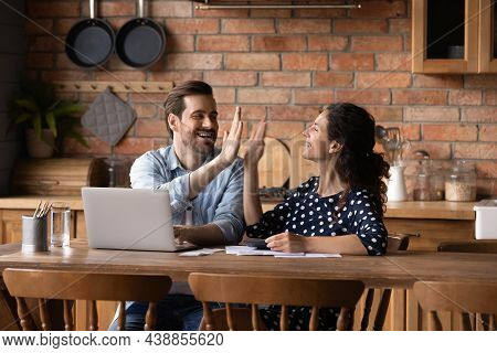 Excited Young Family Couple Raise High Five After Paying Bills