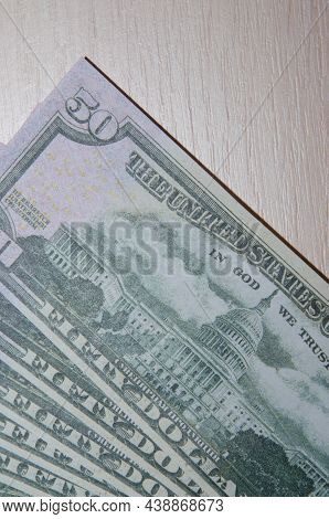 A Stack Of Fifty 50 Dollar Bills Fanned Out On A Wood