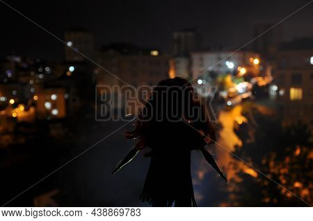 Silhouette Of A Female Face On A Light Background. Silhouette Of A Lonely Doll With Long Hair At Nig