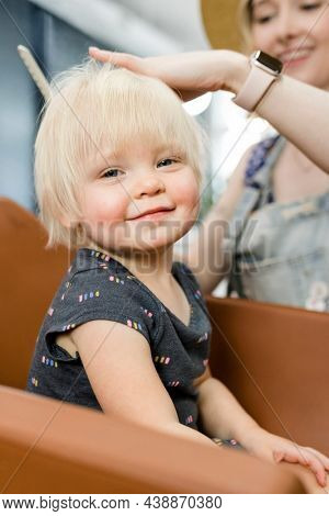 Hairstylist giving a haircut to an adorable blond kid