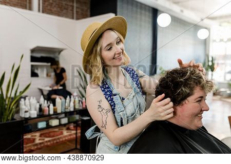 Hairstylist trimming hair of the customer in a beauty salon