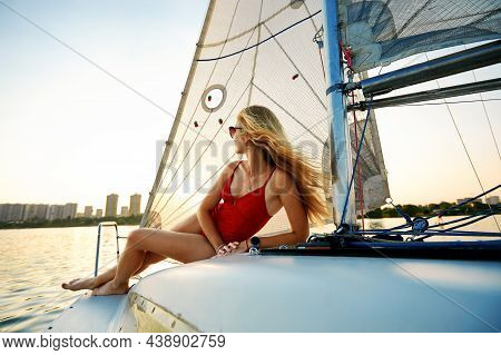 Young Beautiful Woman In Fashion Red Swimsuit Standing On Yacht In Open Sea Or Ocean, Sailing