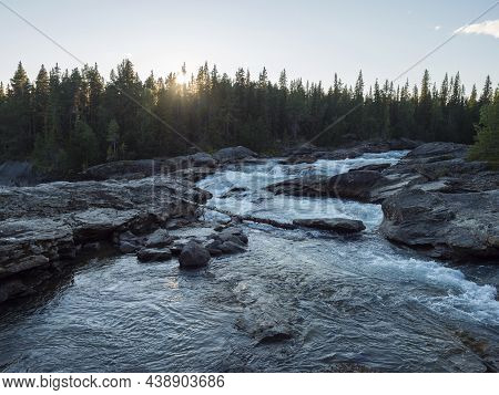 Sunset Over Spruce Tree Forest And Rapids Cascades Of Wild River Kamajokk Near Kvikkjokk Village In 