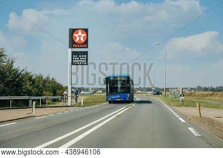 Texel, The Netherlands - Aug 27, 2019: Dutch Highway Street With 28 Bus And Texaco Gas Station Adver