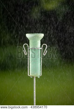 Close Up Of Plastic Rain Gauge On Rainstorm In Garden In Summertime