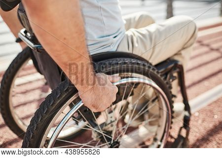 Close Up Of Unrecognizable Adult Man In Wheelchair Outdoors Lit By Sunlight, Copy Space