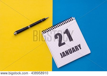 January 21th. Day 21 Of Month. Calendar Date. Notebook With A Spiral And Pen Lies On A Yellow-blue B