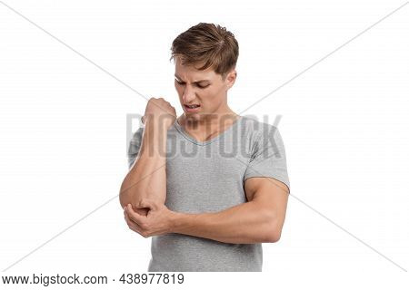 Despaired Young European Handsome Guy Presses His Hand To Sore Spot And Suffers From Pain In Elbow
