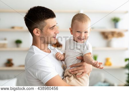 Father And Baby. Happy Young Dad Holding Adorable Toddler Child At Home