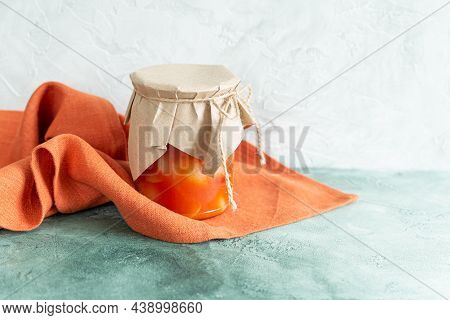 Canned Vegetables In A Glass Jar And A Terracotta Linen Napkin On A Light Green Background. Homemade