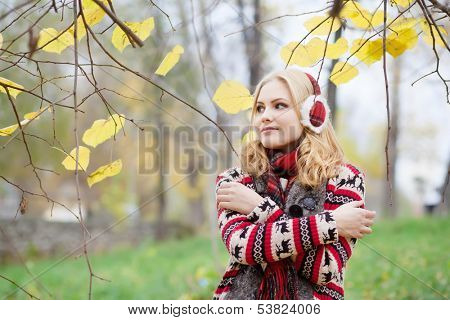girl in fur headphones in the autumn park