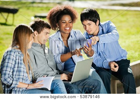 Happy young students with using mobilephone in university campus