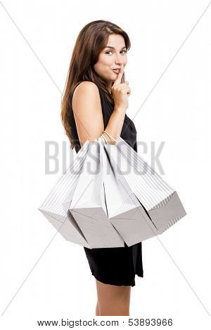Attractive young woman shopping with a naugthy face, isolated over white background