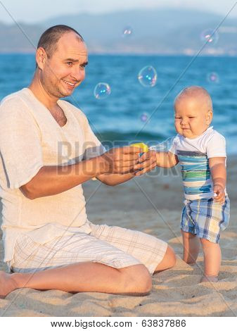 Father and baby are making bubbles