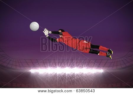Fit goal keeper jumping up against large football stadium with spotlights under purple sky
