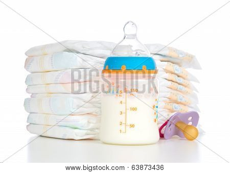 Stack Of Diapers Nipple Soother And Baby Feeding Bottle With Milk