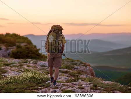 Guy In The Mountains At Sunset. The Concept Of Freedom