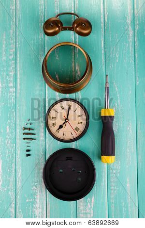 Repair clock on wooden background
