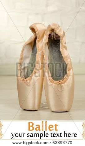 Ballet pointe shoes on floor in dance hall