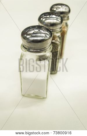 Close Up Salt, Pepper, And Barbecue Classic Shakers On White Background