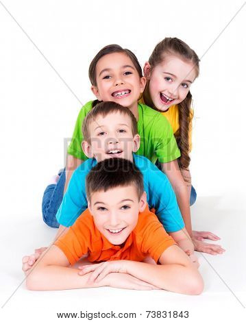 Five beautiful smiling kids lying on the floor in bright colorful t-shirts -  isolated on white.
