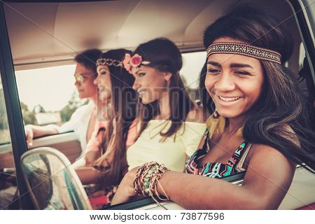 Multi-ethnic hippie friends in a minivan on a road trip