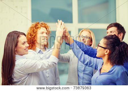 business, office, gesture and startup concept - smiling creative team doing high five gesture in office