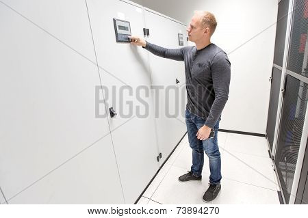 IT engineer adjusts air conditioner in datacenter